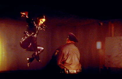 Fotograma de The Matrix (1999) que muestra el tono oscuro y la estética cyberpunk de la escena inicial